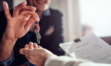 Real estate agent passing keys to his client